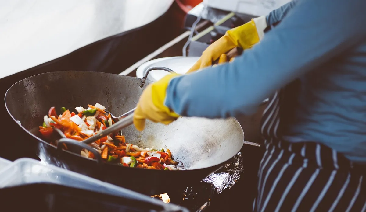 Cuisinier faisant sauter des aliments au wok