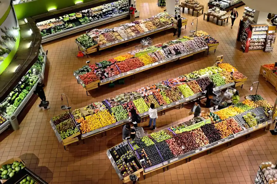 Rayon fruits et légumes d'une épicerie avec employés